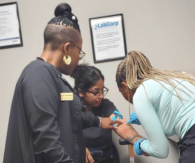 students training to take blood draws with their instructor nearby students training to take blood draws with their instructor nearby